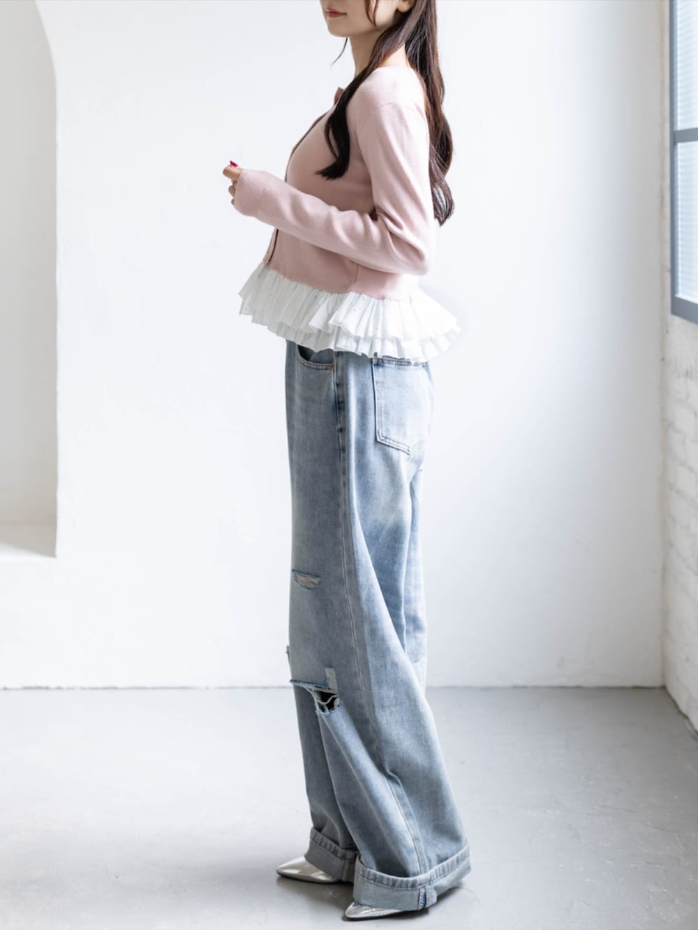シルバー系のパンプス、ブルー系のデニムパンツ、ピンク系のカーディガン/ボレロを着用したレディースの秋コーディネートの3枚目の写真