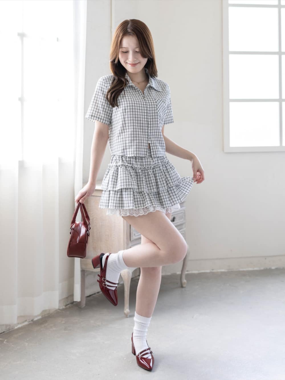 レッド系のパンプス、ホワイト系のスカート、ホワイト系のシャツ/ブラウスを着用したレディースの春コーディネートの2枚目の写真