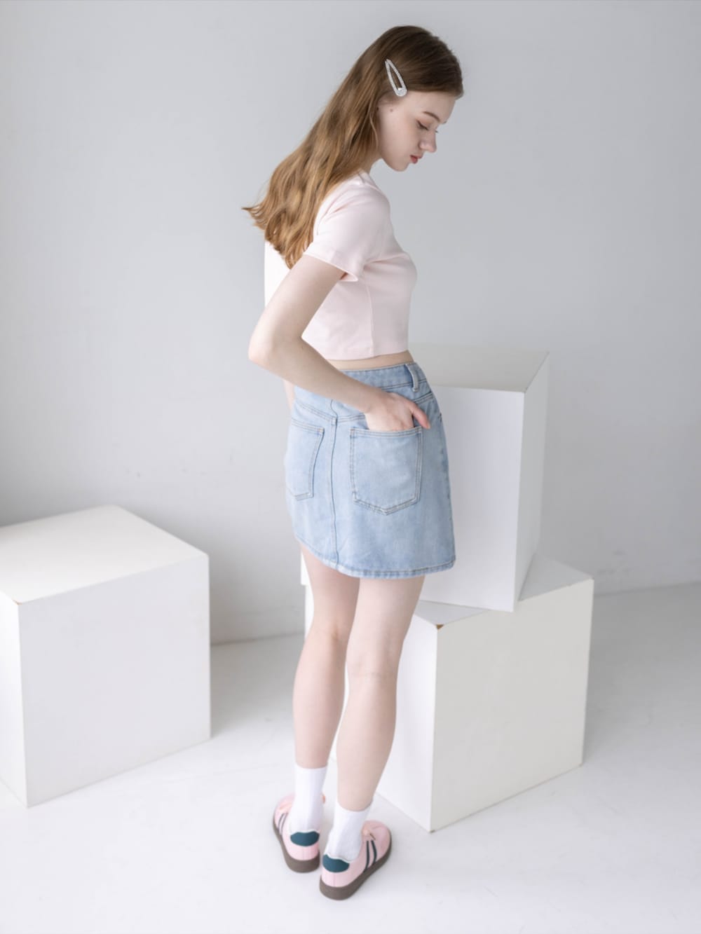 ピンク系のTシャツ/カットソー、ブルー系のデニムスカート、ピンク系のスニーカーを着用したレディースの夏コーディネートの6枚目の写真