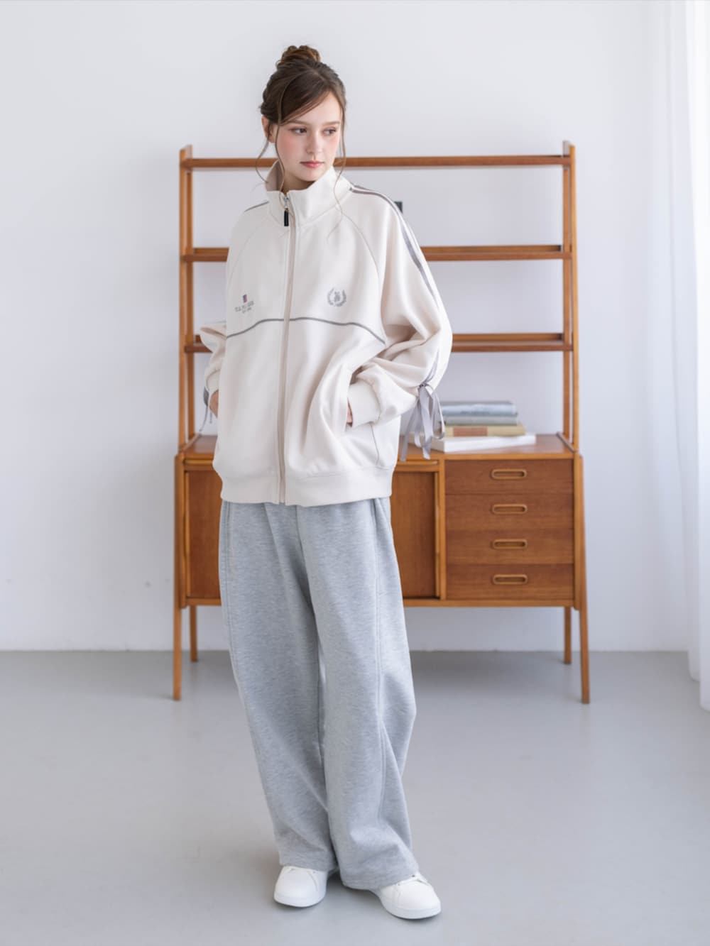ゴールド系のスニーカー、グレー系のスウェットパンツ、ホワイト系のTシャツ/カットソーを着用したレディースの秋コーディネートの3枚目の写真