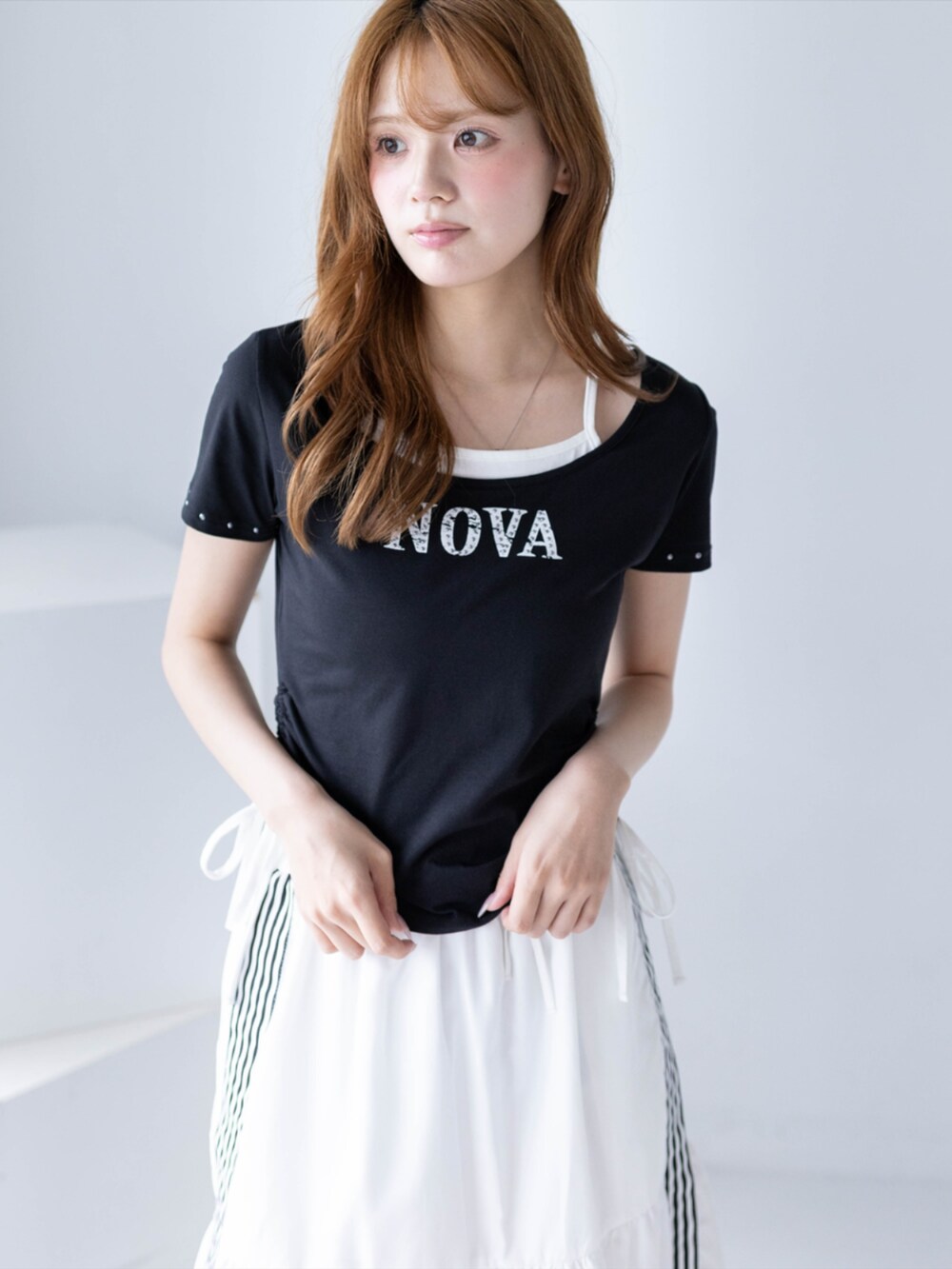 ブラック系のブーツ、ホワイト系のスカート、ブラック系のTシャツ/カットソーを着用したレディースの夏コーディネートの6枚目の写真