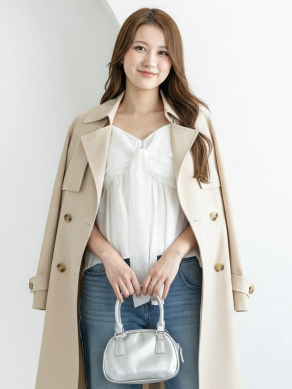 シルバー系のパンプス、ブルー系のデニムパンツ、ホワイト系のキャミソールを着用したレディースの冬コーディネートの4枚目の写真