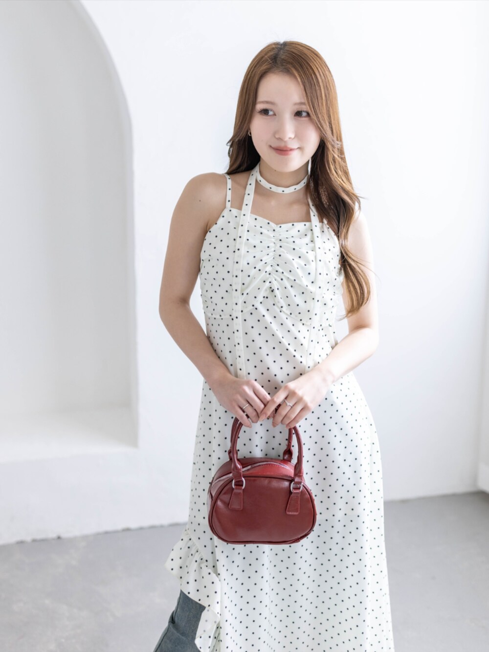 レッド系のパンプス、ブルー系のデニムパンツ、ホワイト系のワンピースを着用したレディースの夏コーディネートの6枚目の写真