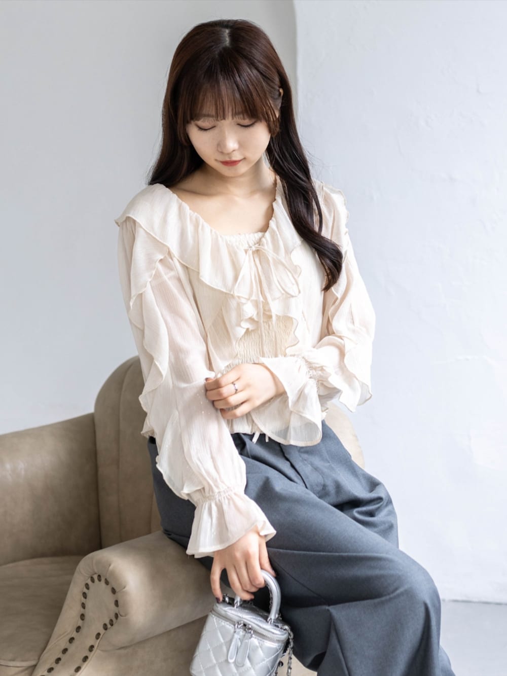 シルバー系のパンプス、ブラック系のスラックス、ベージュ系のシャツ/ブラウスを着用したレディースの春コーディネートの3枚目の写真