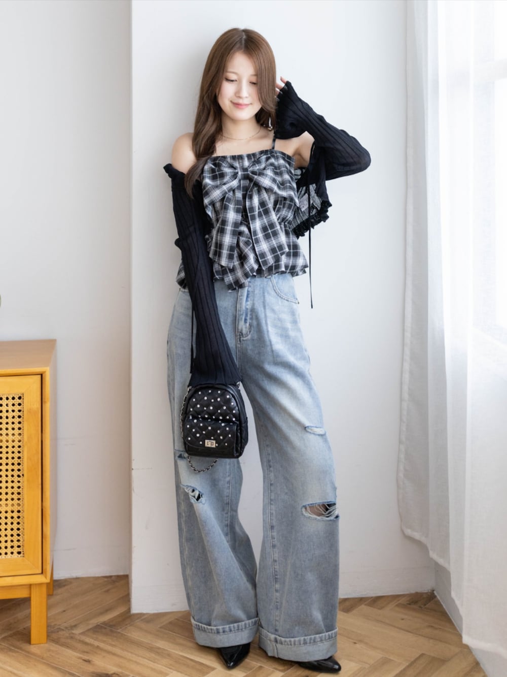 ブラック系のパンプス、ブラック系のカーディガン/ボレロ、ブルー系のデニムパンツを着用したレディースの夏コーディネートの2枚目の写真