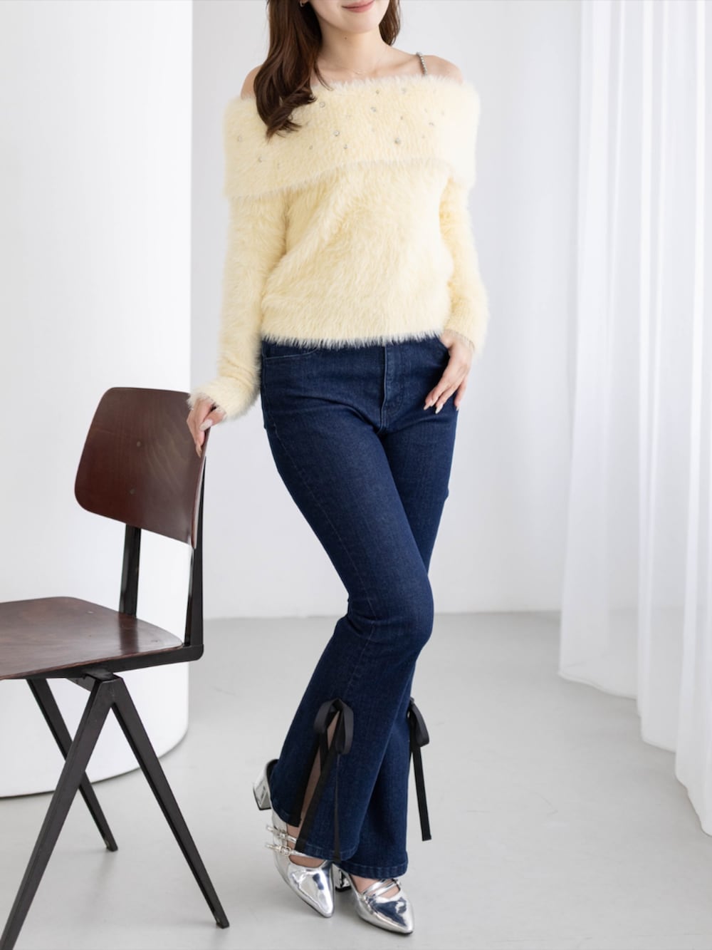シルバー系のパンプス、ブルー系のデニムパンツ、イエロー系のニット/セーターを着用したレディースの秋コーディネートの4枚目の写真