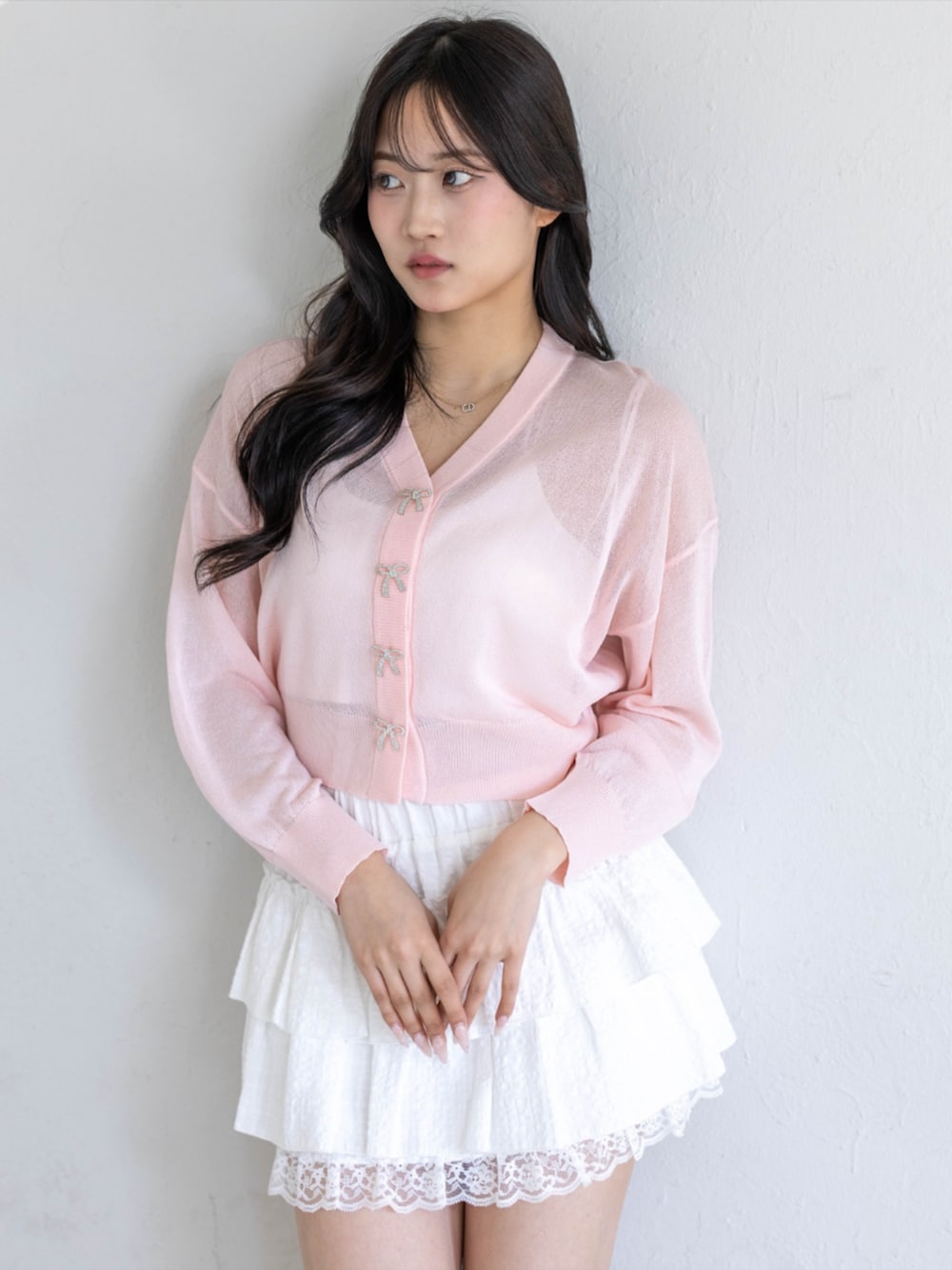 ホワイト系のスカート、ホワイト系のパンプス、ピンク系のカーディガン/ボレロを着用したレディースの春コーディネートの3枚目の写真