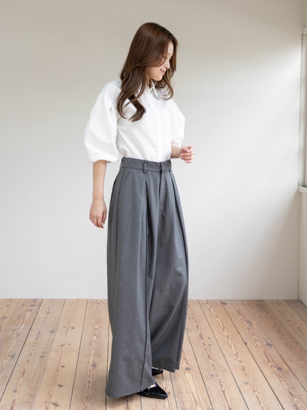 ブラック系のパンプス、グレー系のその他パンツ、ホワイト系のシャツ/ブラウスを着用したレディースの春コーディネートの2枚目の写真