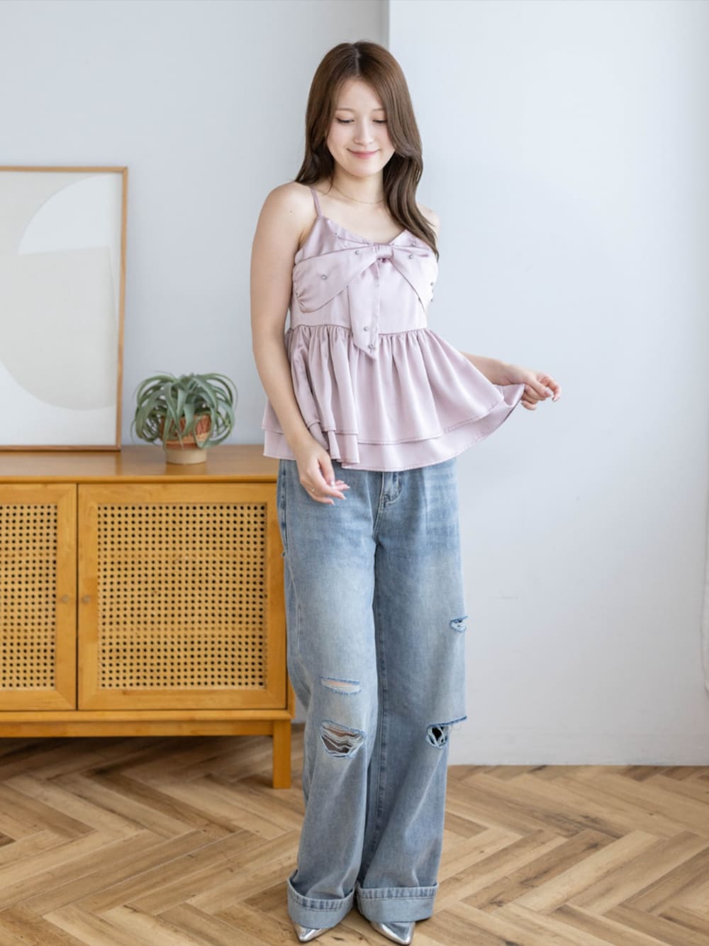 シルバー系のパンプス、ブルー系のデニムパンツ、ピンク系のキャミソールを着用したレディースの夏コーディネートの2枚目の写真
