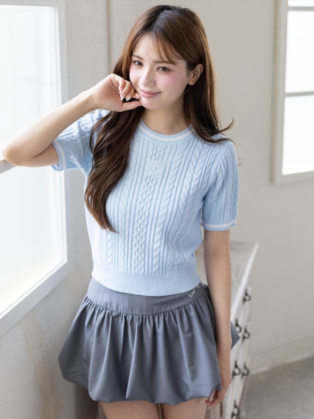 シルバー系のパンプス、グレー系のスカート、ブルー系のニット/セーターを着用したレディースの夏コーディネートの5枚目の写真