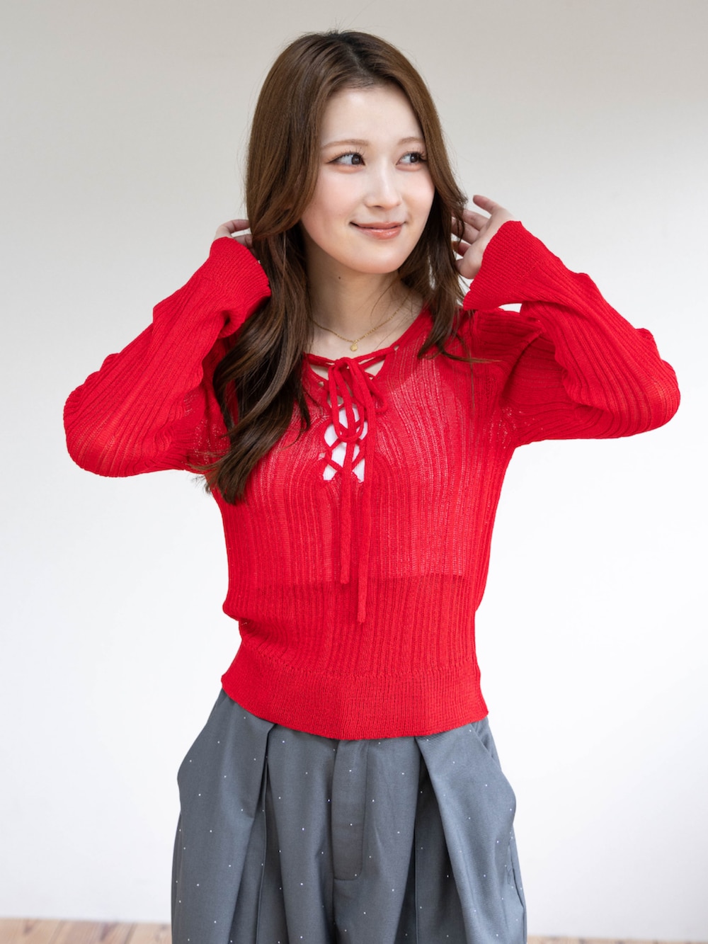 シルバー系のパンプス、レッド系のニット/セーター、グレー系のその他パンツを着用したレディースの春コーディネートの7枚目の写真