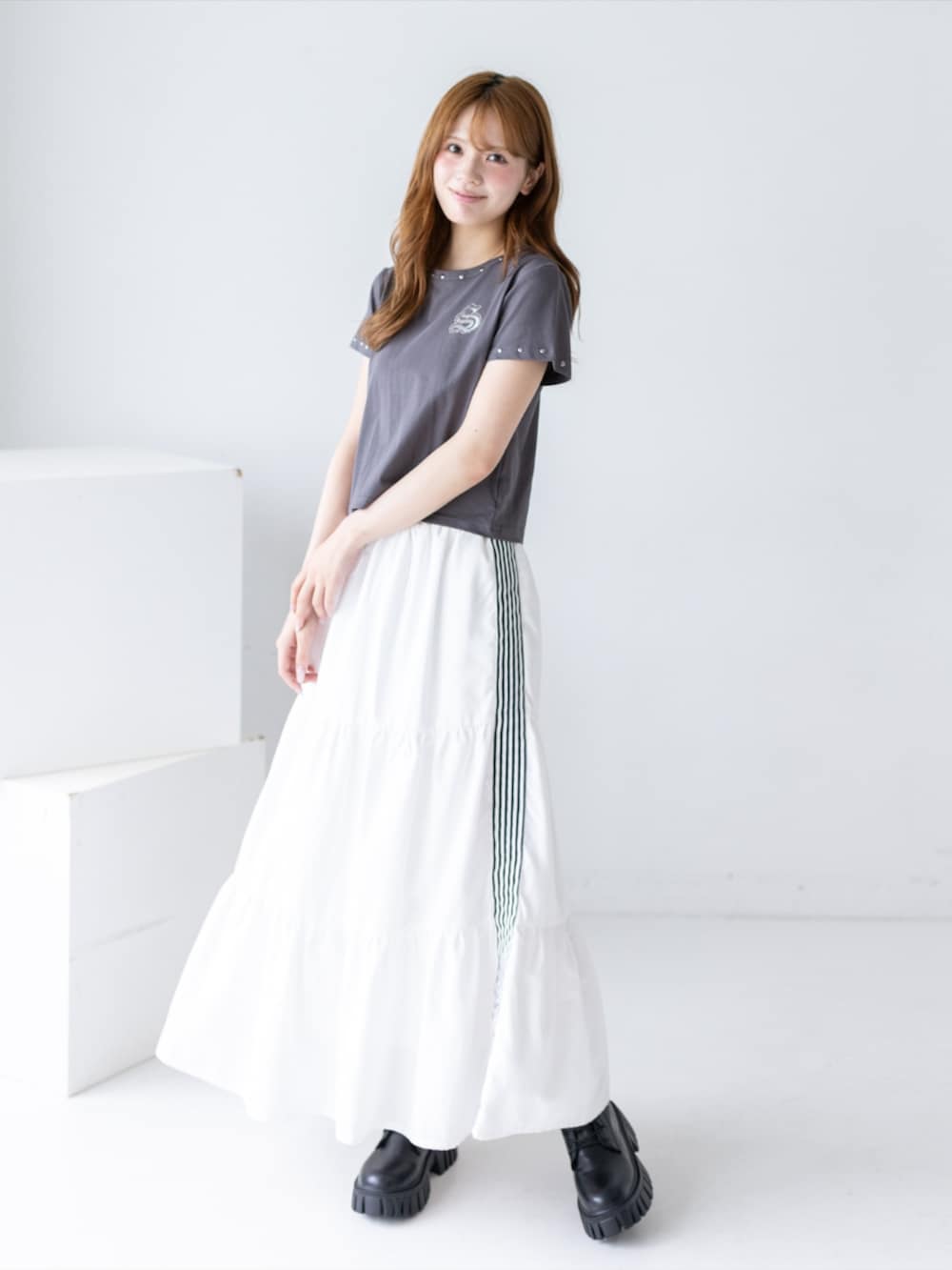 ブラック系のブーツ、ホワイト系のスカート、グレー系のTシャツ/カットソーを着用したレディースの夏コーディネートの4枚目の写真