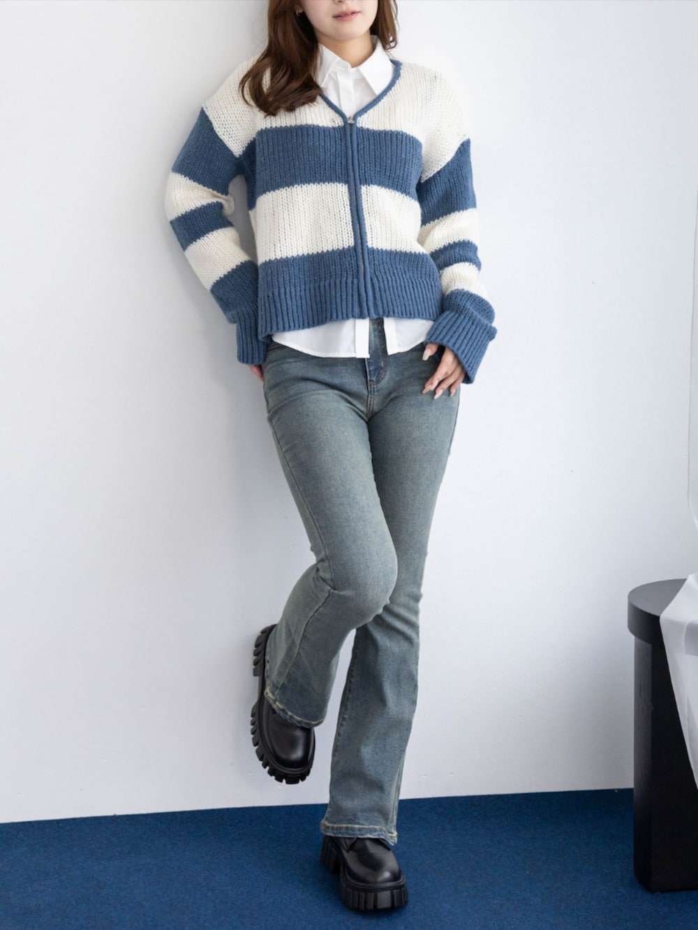 ブルー系のデニムパンツ、ホワイト系のシャツ/ブラウス、ブラック系のブーツを着用したレディースの秋コーディネートの3枚目の写真