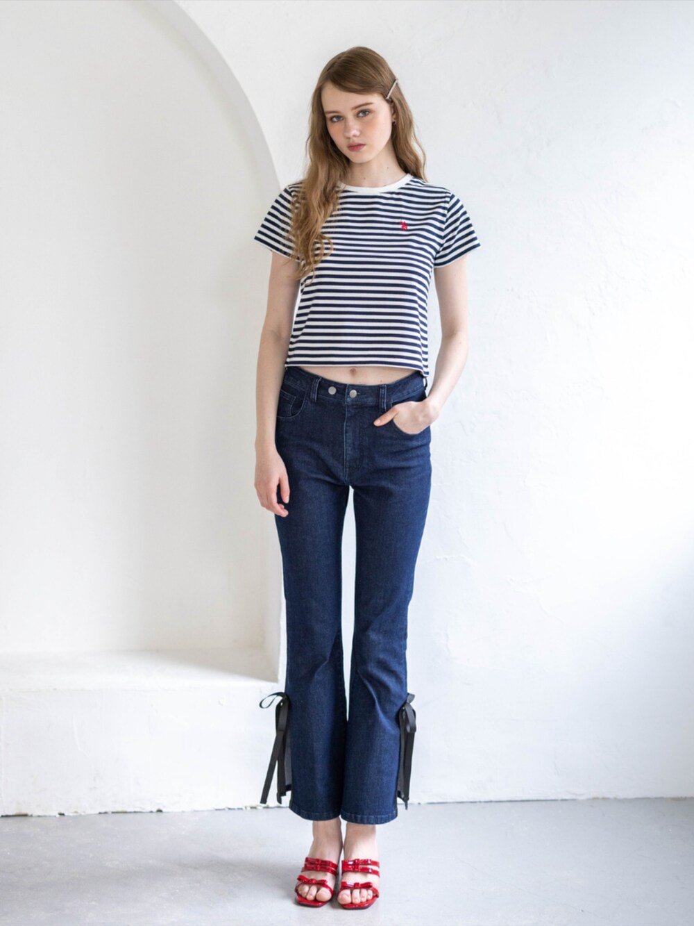 レッド系のサンダル、ブルー系のデニムパンツ、ホワイト系のTシャツ/カットソーを着用したレディースの夏コーディネートの2枚目の写真