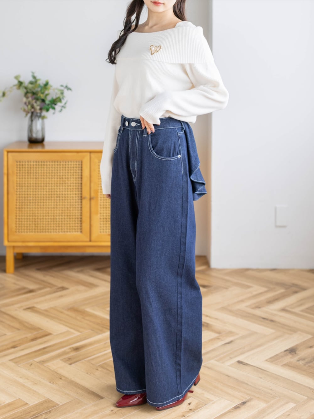 レッド系のパンプス、ブルー系のデニムパンツ、ホワイト系のニット/セーターを着用したレディースの秋コーディネートの3枚目の写真