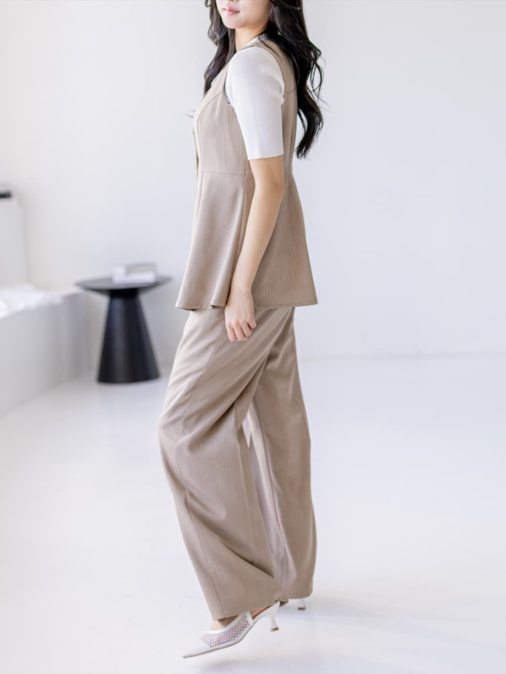 ホワイト系のニット/セーター、ベージュ系のスラックス、ホワイト系のパンプスを着用したレディースの夏コーディネートの4枚目の写真