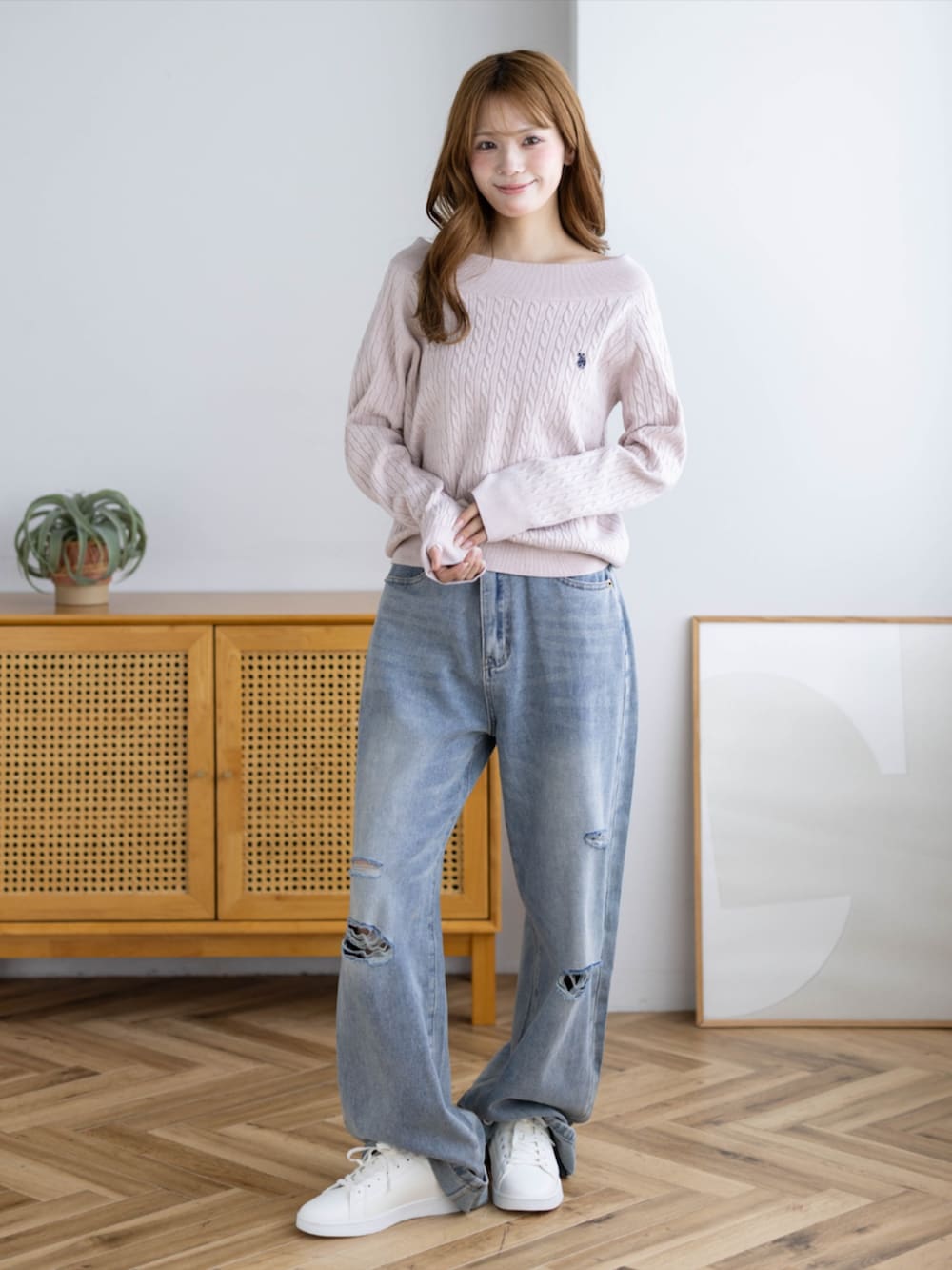 ピンク系のスニーカー、ブルー系のデニムパンツ、ピンク系のニット/セーターを着用したレディースの秋コーディネートの2枚目の写真