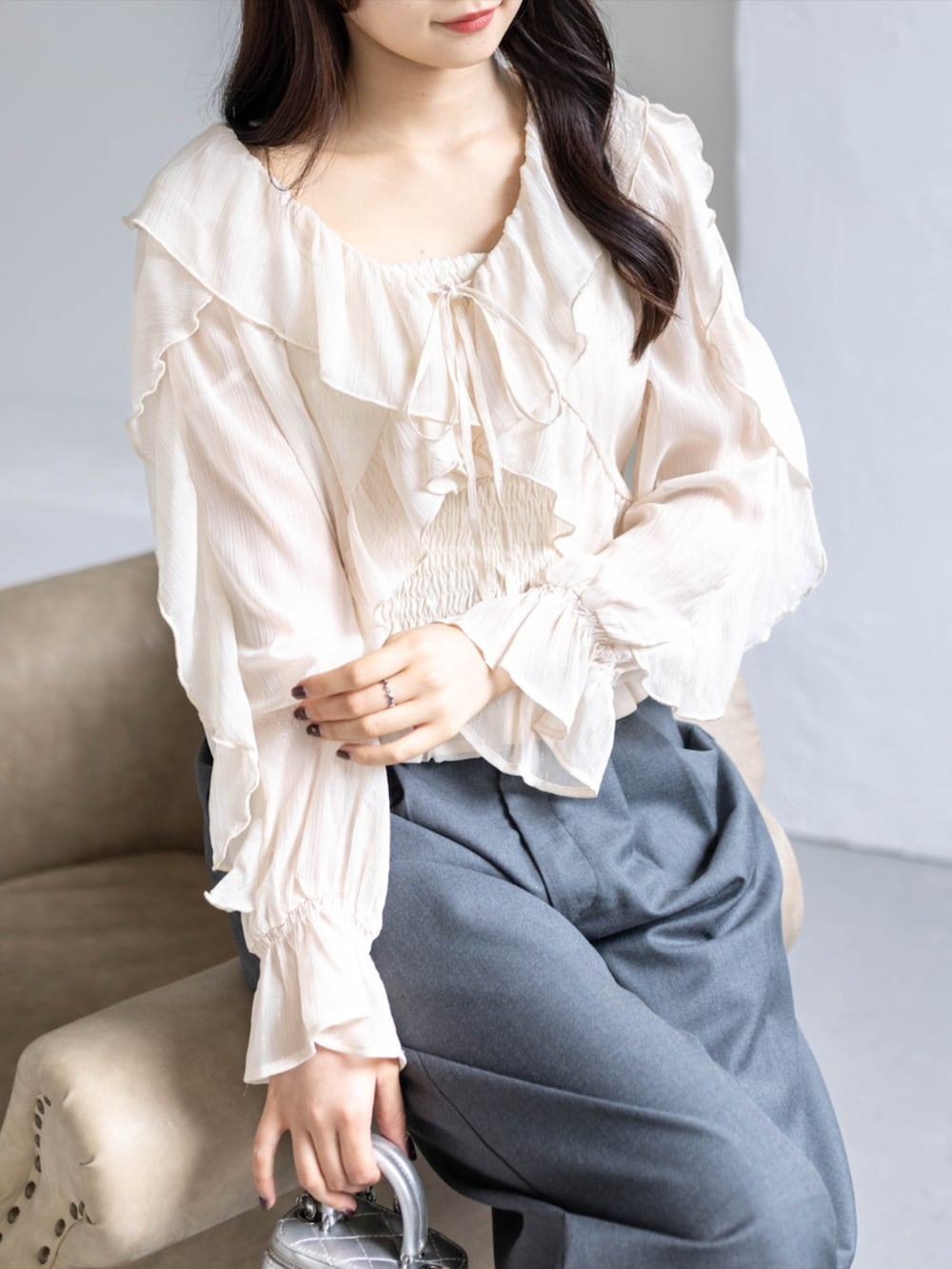 シルバー系のパンプス、ブラック系のスラックス、ベージュ系のシャツ/ブラウスを着用したレディースの春コーディネートの4枚目の写真