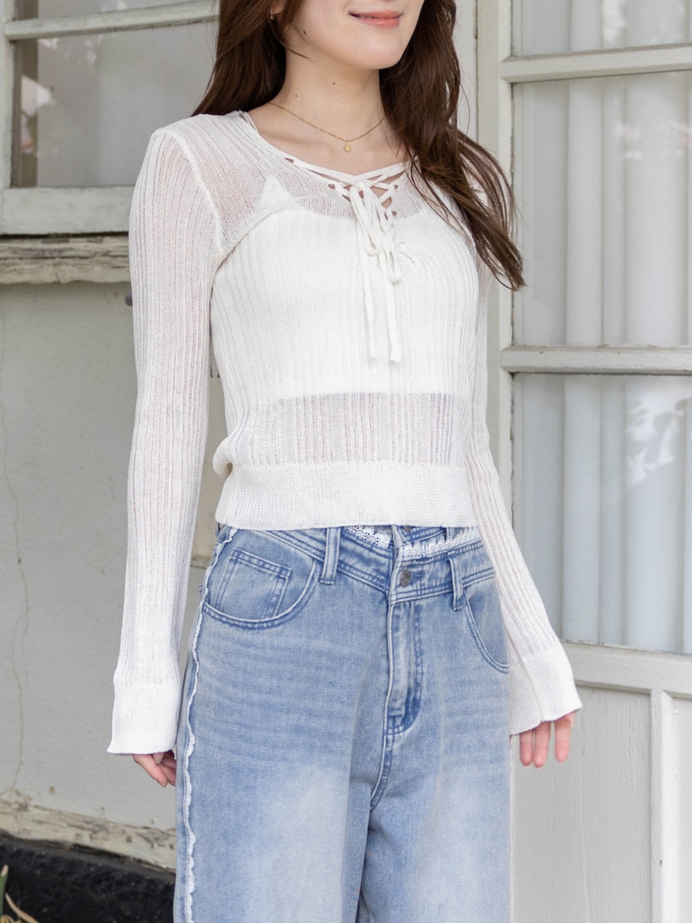 シルバー系のパンプス、ブルー系のデニムパンツ、ホワイト系のニット/セーターを着用したレディースの春コーディネートの6枚目の写真