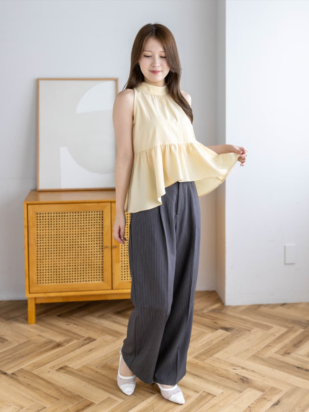 ホワイト系のパンプス、グレー系のスラックス、イエロー系のシャツ/ブラウスを着用したレディースの夏コーディネートの2枚目の写真
