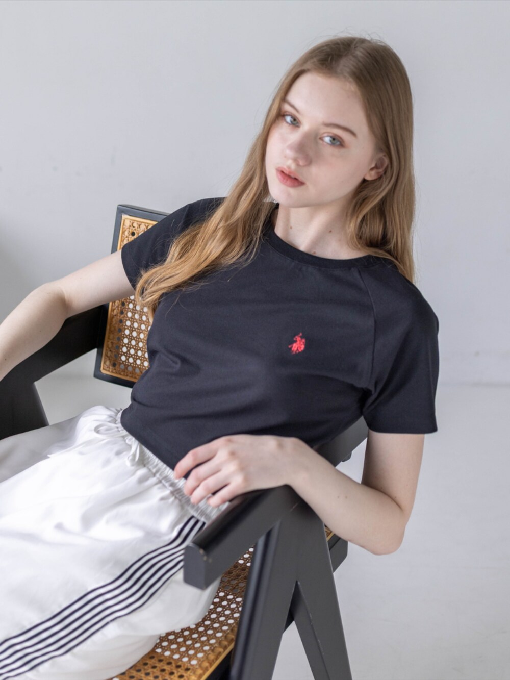 ブラック系のスニーカー、ホワイト系のスカート、ブラック系のTシャツ/カットソーを着用したレディースの夏コーディネートの8枚目の写真