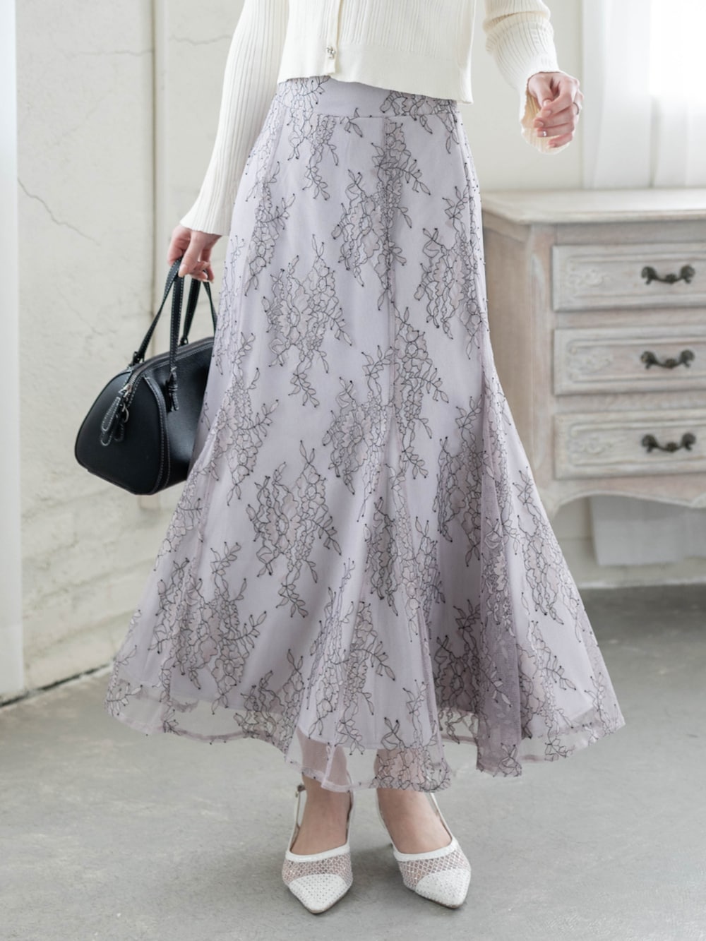 ホワイト系のカーディガン/ボレロ、グレー系のスカートを着用したレディースの冬コーディネートの4枚目の写真