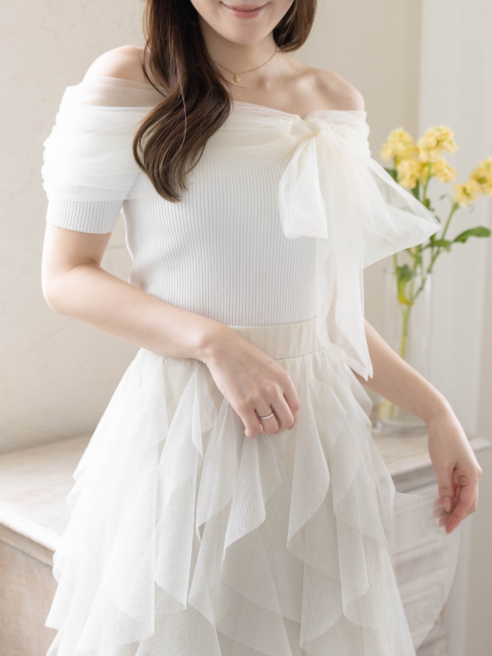 ホワイト系のニット/セーター、ホワイト系のパンプス、ホワイト系のスカートを着用したレディースの春コーディネートの6枚目の写真