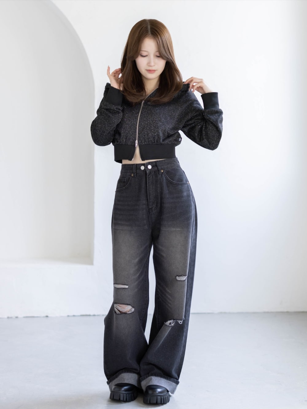 ブラック系のブーツ、ブラック系のデニムパンツ、ブラック系のパーカーを着用したレディースの夏コーディネートの2枚目の写真