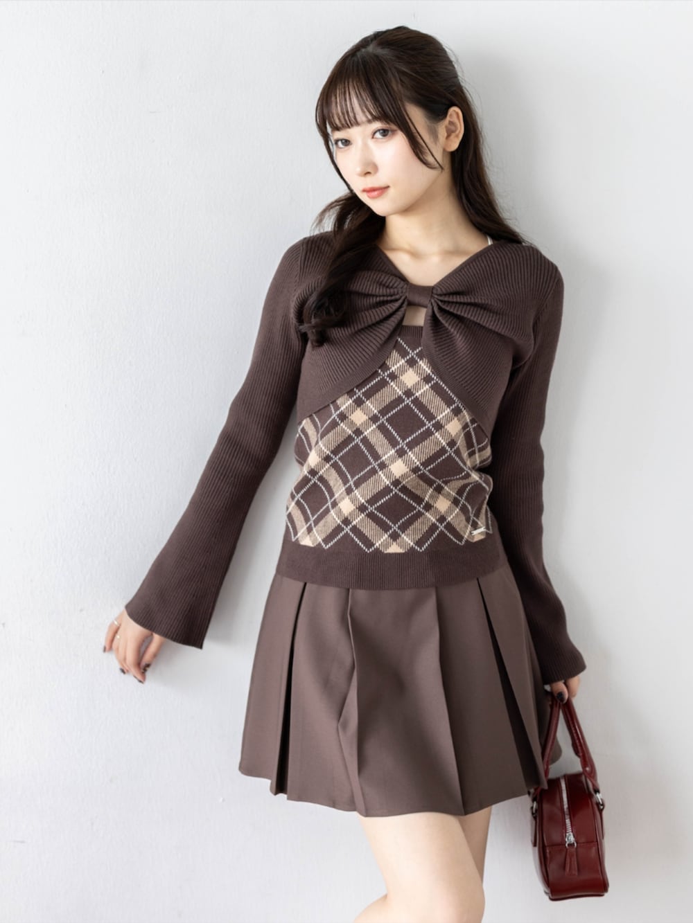 レッド系のパンプス、ブラウン系のスカート、ブラウン系のニット/セーターを着用したレディースの秋コーディネートの2枚目の写真