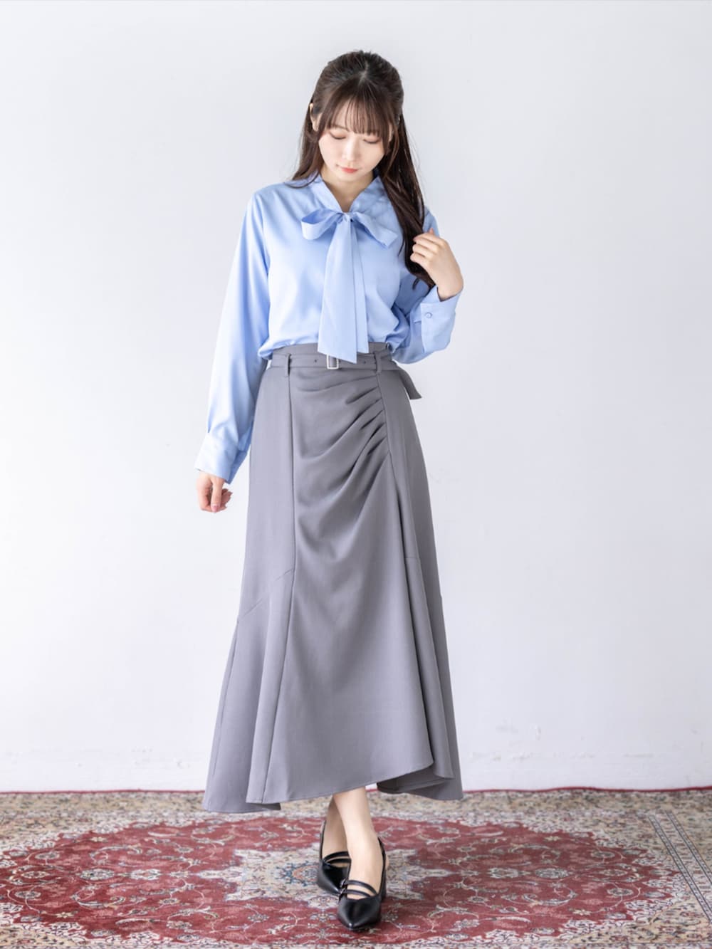 ブラック系のパンプス、グレー系のスカート、ブルー系のシャツ/ブラウスを着用したレディースの夏コーディネートの2枚目の写真