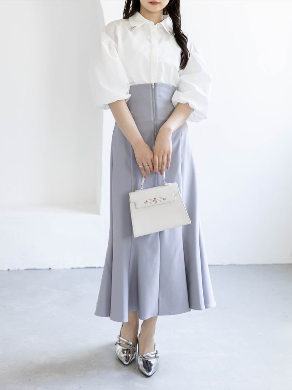シルバー系のパンプス、ホワイト系のシャツ/ブラウス、グレー系のスカートを着用したレディースの夏コーディネートの4枚目の写真