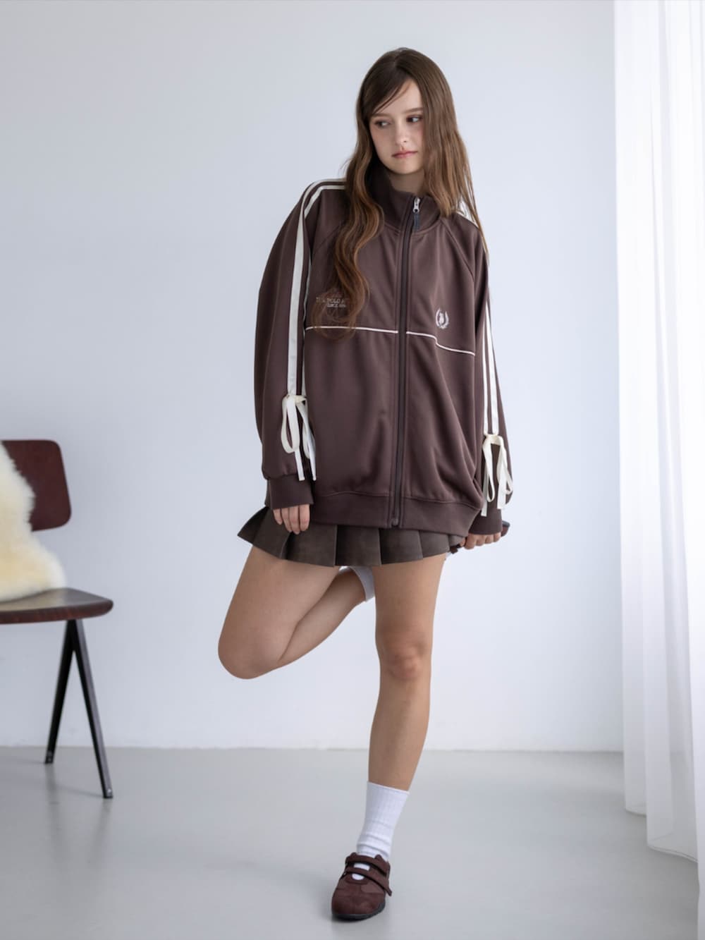 ブラウン系のスカート、ブラウン系のTシャツ/カットソー、ブラウン系のスニーカーを着用したレディースの秋コーディネートの2枚目の写真