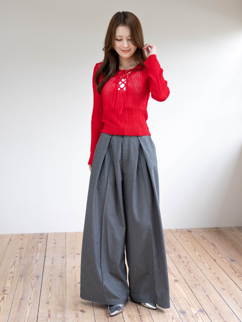 シルバー系のパンプス、レッド系のニット/セーター、グレー系のその他パンツを着用したレディースの春コーディネートの4枚目の写真