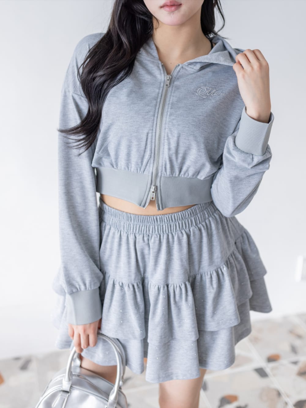 シルバー系のパンプス、グレー系のパーカー、グレー系のスカートを着用したレディースの春コーディネートの4枚目の写真