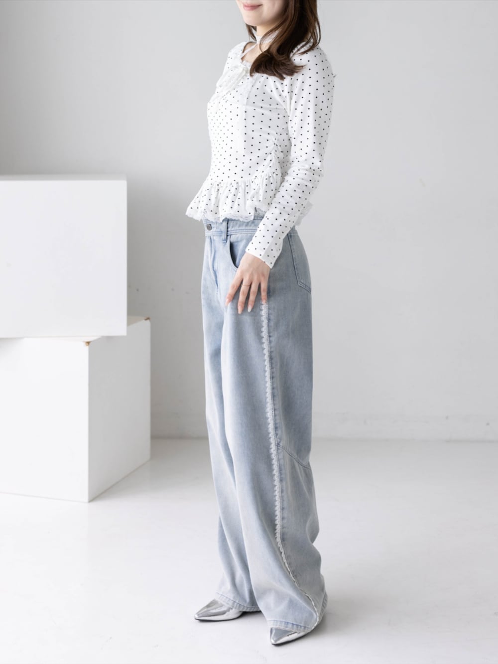 シルバー系のパンプス、ブルー系のデニムパンツ、ホワイト系のTシャツ/カットソーを着用したレディースの秋コーディネートの3枚目の写真