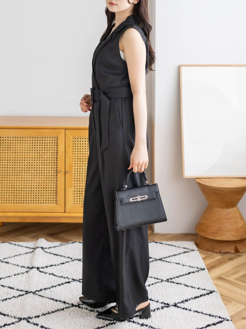 ブラック系のパンプス、ブラック系のハンドバッグ、ブラック系のつなぎ/オールインワンを着用したレディースの夏コーディネートの3枚目の写真