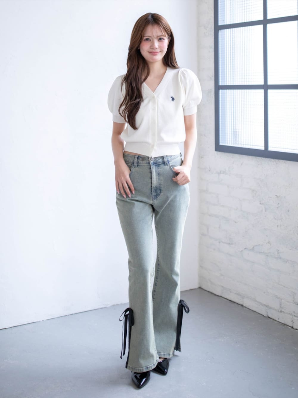ブラック系のパンプス、ブルー系のデニムパンツ、ホワイト系のニット/セーターを着用したレディースの夏コーディネートの2枚目の写真