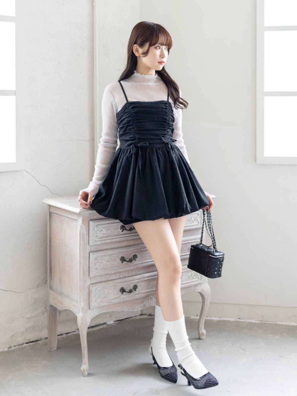 グレー系のTシャツ/カットソー、ブラック系のチュニック、ブラック系のパンプスを着用したレディースの春コーディネートの3枚目の写真