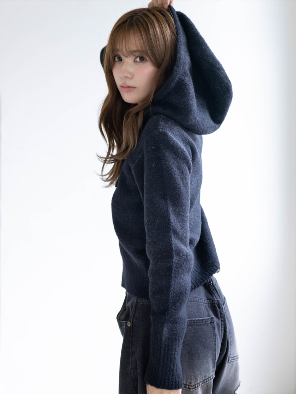 ブラック系のデニムパンツ、ブラック系のブーツ、ブラック系のニット/セーターを着用したレディースの秋コーディネートの5枚目の写真