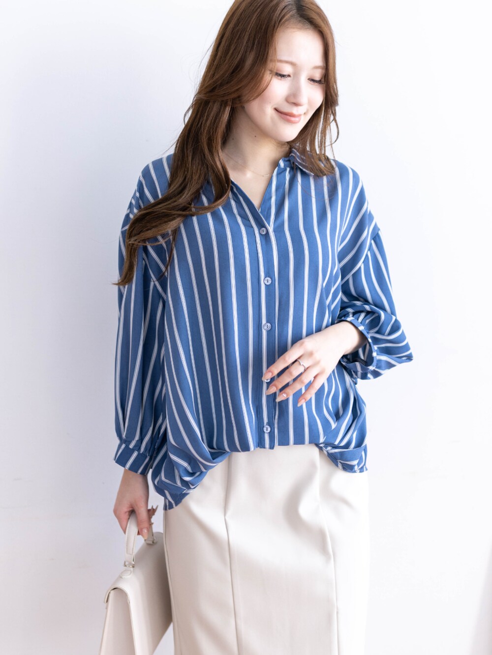 ホワイト系のスカート、ホワイト系のハンドバッグ、ブルー系のシャツ/ブラウスを着用したレディースの冬コーディネートの5枚目の写真