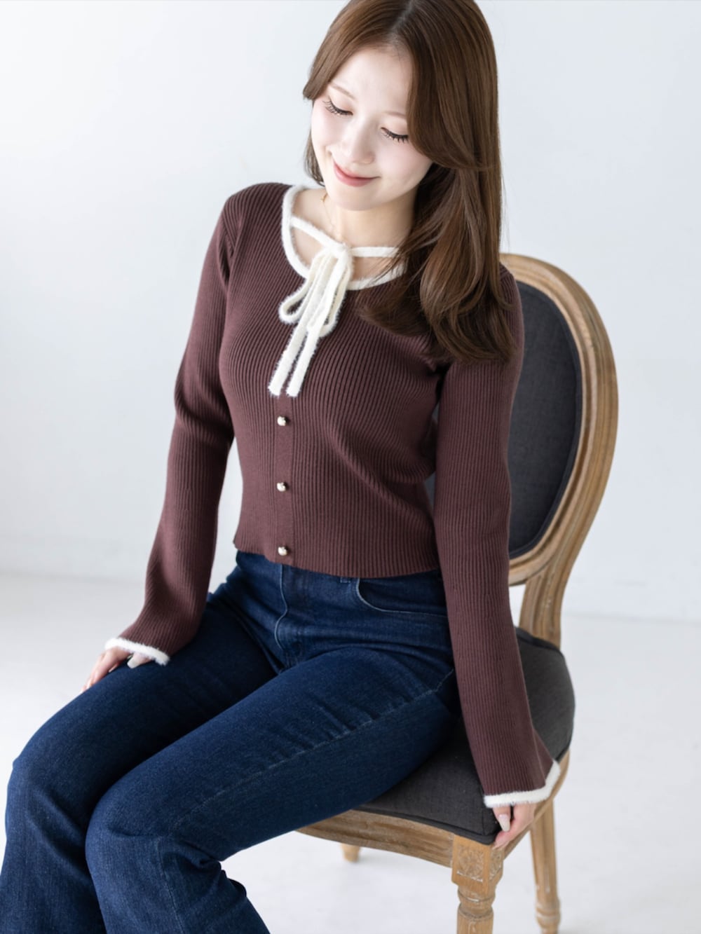 ブルー系のデニムパンツ、ブラック系のパンプス、ブラウン系のニット/セーターを着用したレディースの秋コーディネートの3枚目の写真