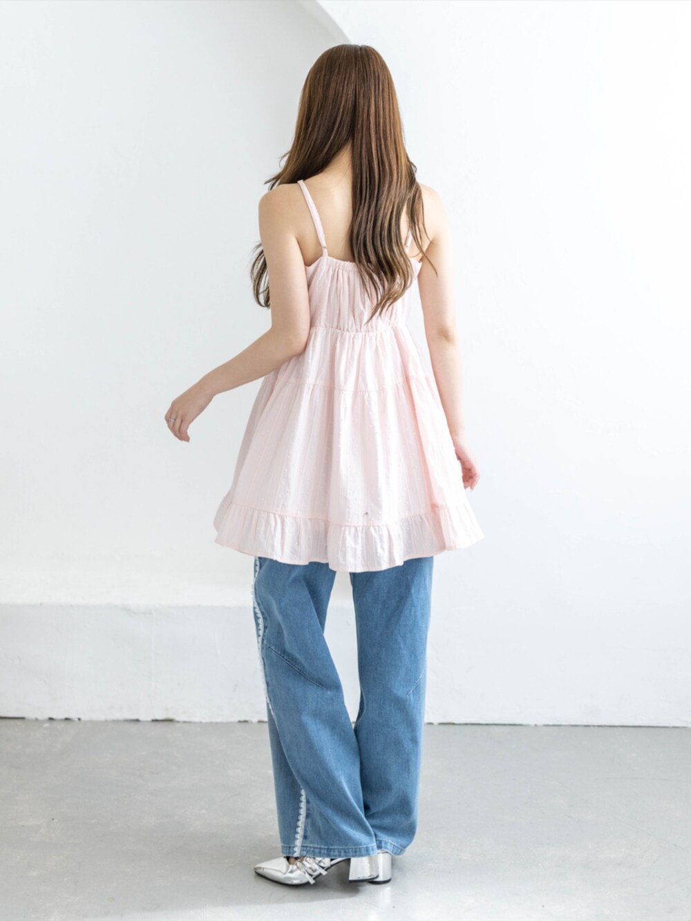 シルバー系のパンプス、ブルー系のデニムパンツ、ピンク系のワンピースを着用したレディースの夏コーディネートの2枚目の写真