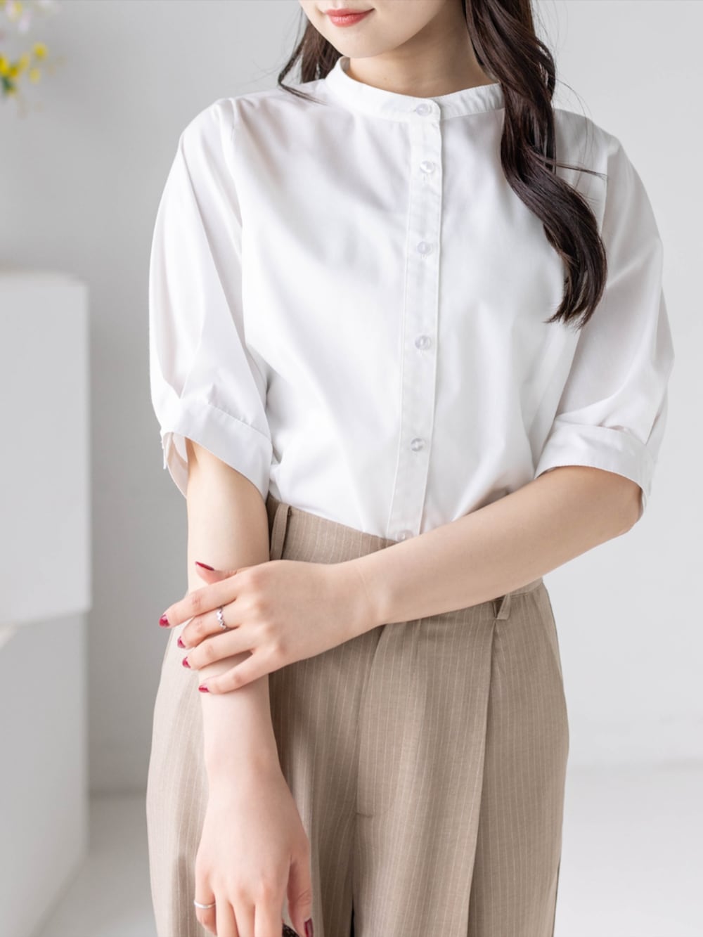 ベージュ系のスラックス、ホワイト系のパンプス、ホワイト系のシャツ/ブラウスを着用したレディースの夏コーディネートの8枚目の写真
