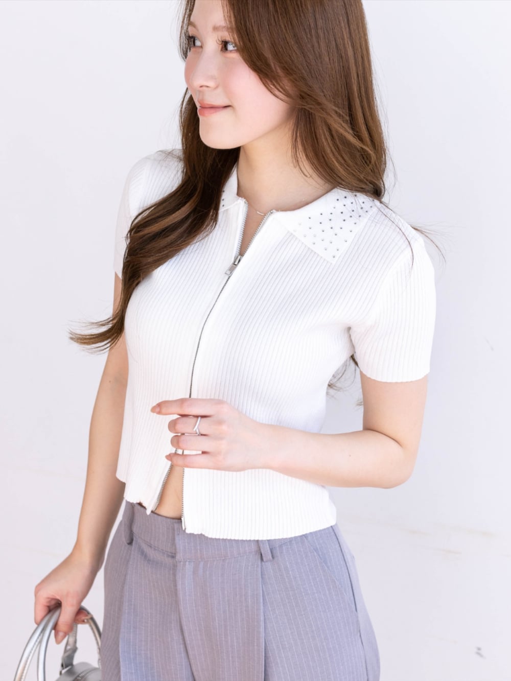 グレー系のスラックス、ホワイト系のパンプス、ホワイト系のニット/セーターを着用したレディースの春コーディネートの5枚目の写真