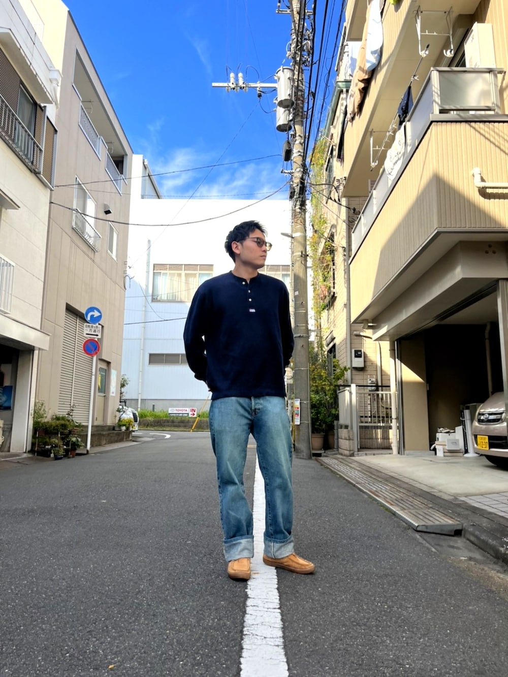 ブルー系のニット/セーター、ブルー系のデニムパンツ、ベージュ系のモカシン/デッキシューズを着用したメンズの秋コーディネートの2枚目の写真