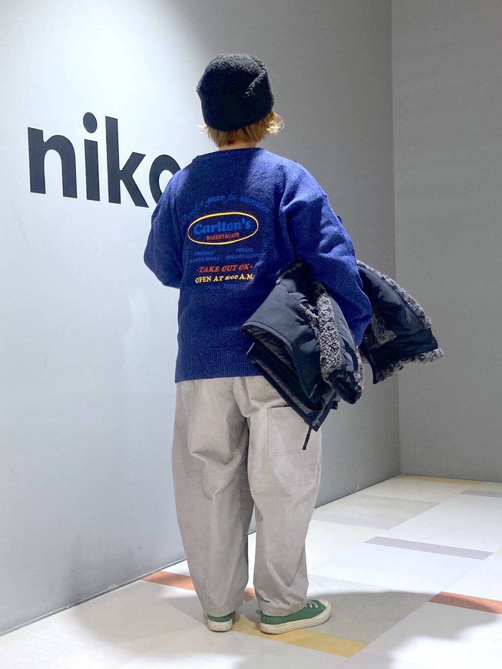 グレー系のブルゾン、グレー系のその他パンツ、ブルー系のニット/セーターを着用したレディースの冬コーディネートの2枚目の写真