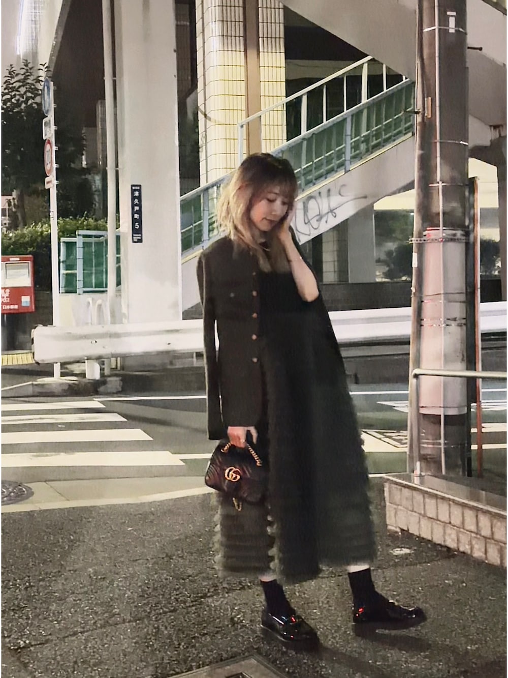 ブラック系のショルダーバッグ、グレー系のスカート、ブラック系のローファーを着用したレディースの秋コーディネートの2枚目の写真