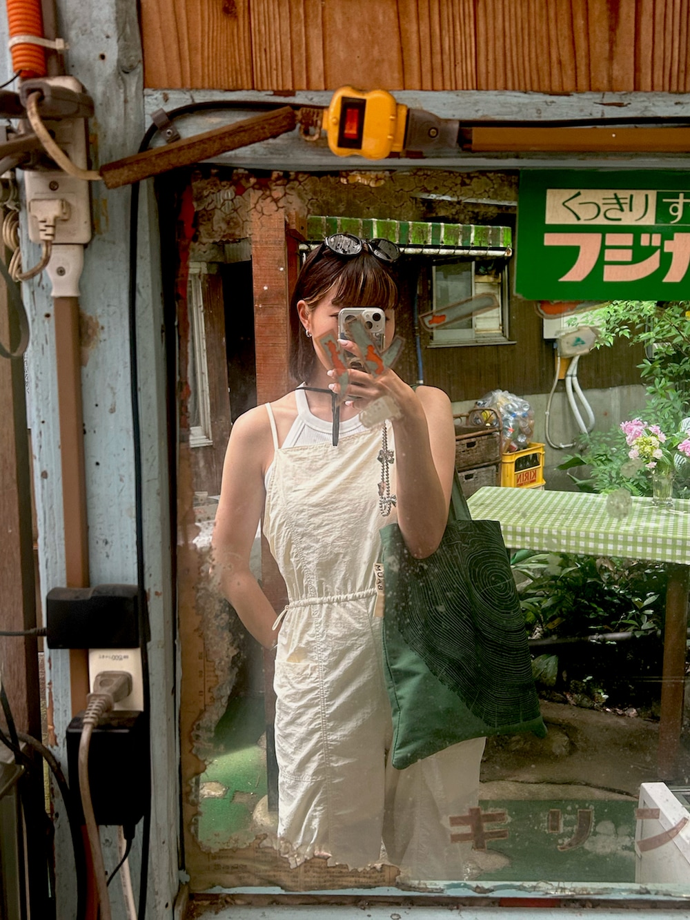 ホワイト系のサロペット/オーバーオール、グリーン系のトートバッグ、ホワイト系のスニーカーを着用したレディースの夏コーディネートの2枚目の写真