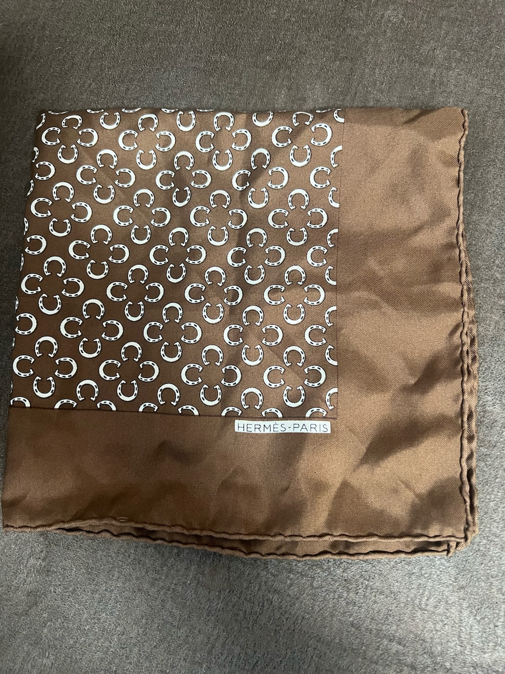 ブラウン系のビジネスシャツ、ブラウン系のネクタイ、ブラウン系のポケットチーフを着用したメンズの春コーディネートの2枚目の写真