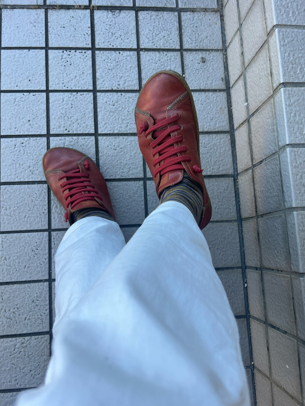 イエロー系のダウンジャケット/コート、イエロー系のショルダーバッグ、レッド系のスニーカーを着用したメンズの冬コーディネートの2枚目の写真